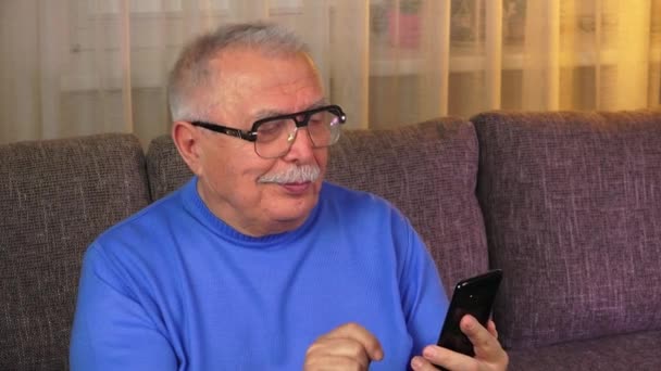 Modern grandfather calls granddaughter sitting on sofa — Stock Video