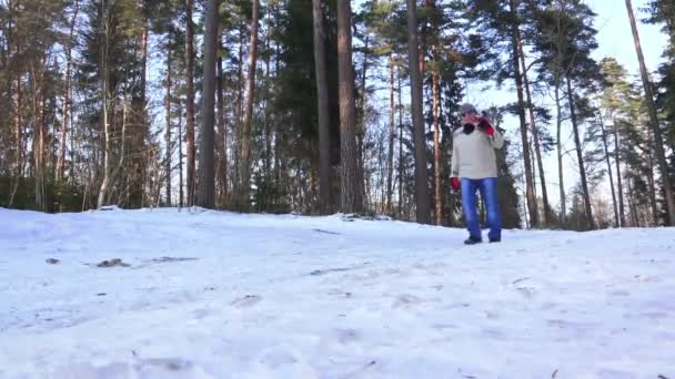 Мужчина в синих джинсах свитер и солнечные очки идут с лыжами — стоковое видео