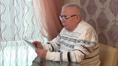 Sweatshirt giyen yaşlı adam elinde kendi portresini taşıyor.