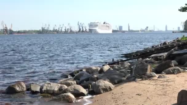 Річка з хвилями й сірими камінцями на піщаному березі проти лайнера. — стокове відео
