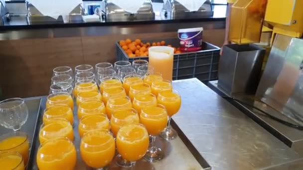 El personal de la cocina del hotel elabora deliciosos zumos de naranja recién hechos en gafas. — Vídeos de Stock