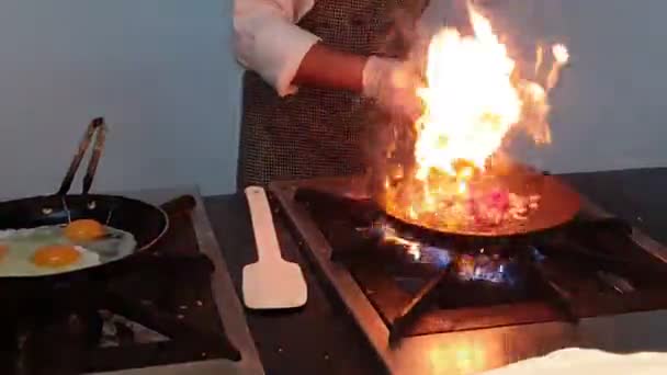 El chef del hotel mezcla con precisión ingredientes que se frecuenta en la sartén. — Vídeos de Stock