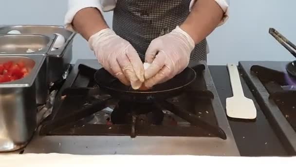 Hotelowy kucharz umieszcza dokładnie jaja kurczaka na patelni — Wideo stockowe
