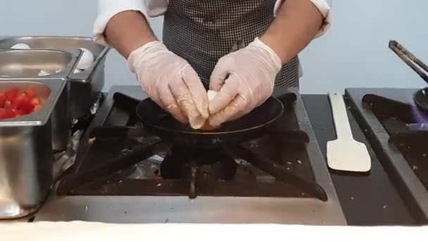 Chef d'hôtel met précisément des oeufs de poule dans la poêle — Video