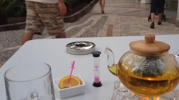 Ceremonia de té con rodajas de naranja y cristal de hora con arena rosa. — Vídeos de Stock