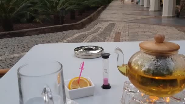 Uvolněný černý čaj obřad s pěkným skleněným šálkem a konvicí — Stock video