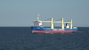 okyanus arasında kırmızı ve mavi kanat yelkenleri ile handysize gemi