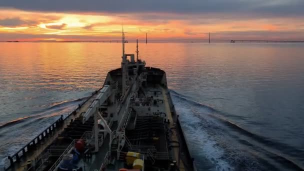 Vrachtschip met antennes op boeg zeilen op de rivier bij zonsondergang — Stockvideo