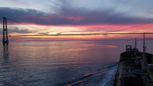 Bulk carrier silhouette sails to bridge under evening sky — Stock Video