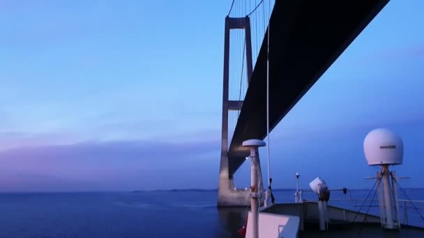 Ship with antennas on bow sails under bridge with lights — Stock Video