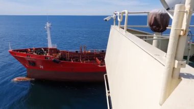 Kırmızı kargo gemisi yaz aylarında beyaz geminin arkasında görünür