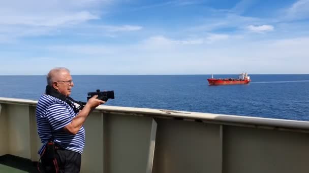 Ciudadano de la tercera edad hace vídeo de vela barco rojo en verano — Vídeo de stock