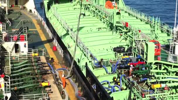 Schiffsarbeiter bewegt riesigen grauen Ölförderschlauch auf Tanker — Stockvideo