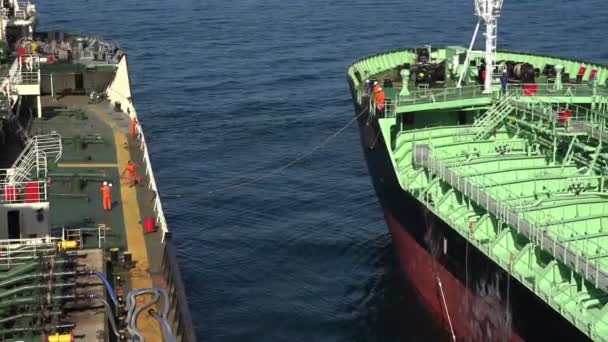 Современный нефтяной танкер с людьми причаливает к огромному навалочному носителю — стоковое видео