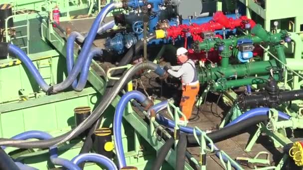 Professional worker connects grey hosepipe to green spigot — Stock Video