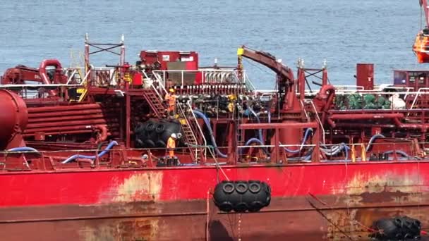 Kırmızı petrol tankeri vinç mavi su üzerinde varil aşağı koyar — Stok video