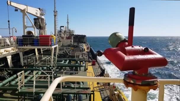Red oil tanker lever against modern pipes and crane on deck — Stock Video