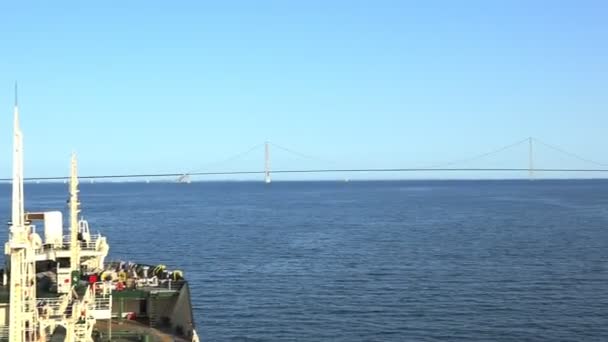 Silueta puente largo sobre río sin fin bajo cielo azul — Vídeo de stock