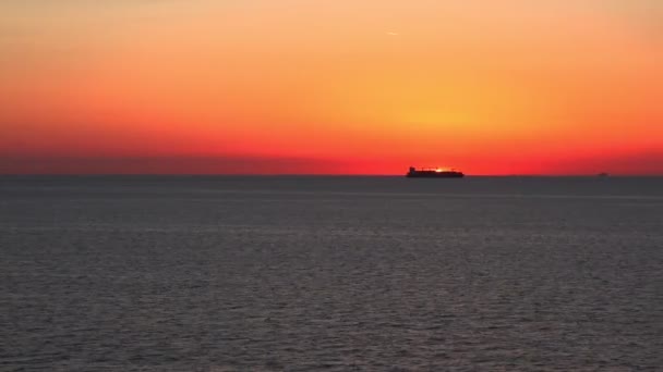 Об'ємний силует носія ховає сонце в помаранчевому червоному вечірньому небі — стокове відео