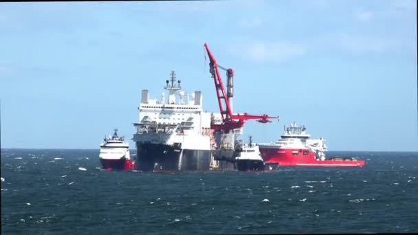 Motorboten begeleiden heavy lift schip met grote kraan — Stockvideo