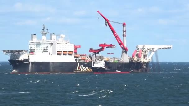 Barco de elevación pesada con grandes grúas rojas velas en el mar azul — Vídeo de stock