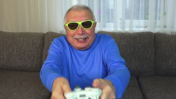 Alegre anciano en azul sudadera juega estación de juego — Vídeo de stock