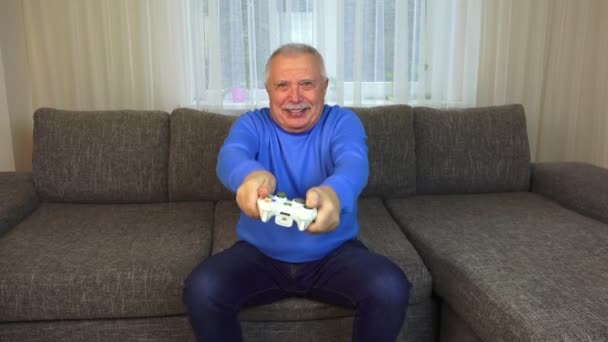 Man shakes white console and plays interesting video game — Stock Video