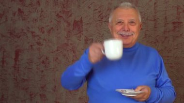 yaşlı adam kırmızı duvara karşı duruyor ve içecekler sıcak yeşil çay