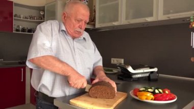 yaşlı adam gemide büyük gri çelik bıçak ile çavdar ekmeği dilimleri