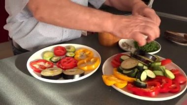 adam elleri büyük tabaktan patlıcan ve domates dilimleri almak