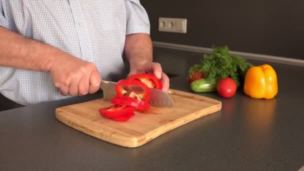 Hombre manos agarrar y cortar el pimiento rojo dulce en la tabla de cortar — Vídeos de Stock