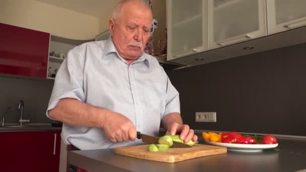 Koncentrovaný muž s šedým knírkem střihne cuketa na palubě — Stock video