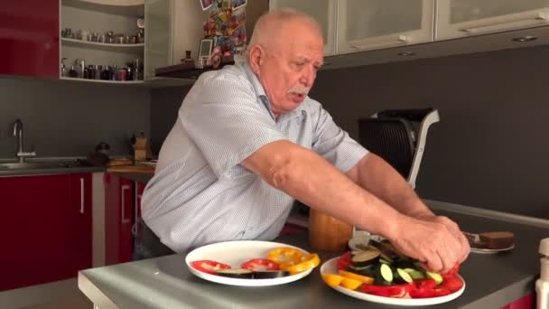 Hombre toma trozos de calabacín y pone en rodaja de pimiento — Vídeo de stock