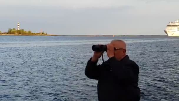 Gentleman looks igenom kikare mot den Daugava floden — Stockvideo