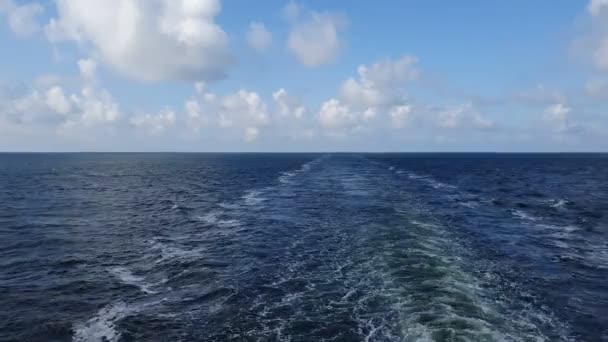 Eindeloze blauwe zee golven met wit schuim na zeilschip — Stockvideo