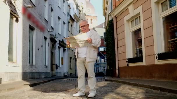 Senior man kijkt naar kaart op verharde straat in de prachtige stad — Stockvideo