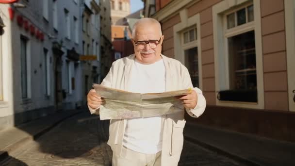 Érett turista néz ki a térképen álló gyönyörű épületek — Stock videók