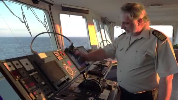 Капитан корабля разговаривает по телефону и смотрит на голубое бесконечное море — стоковое видео