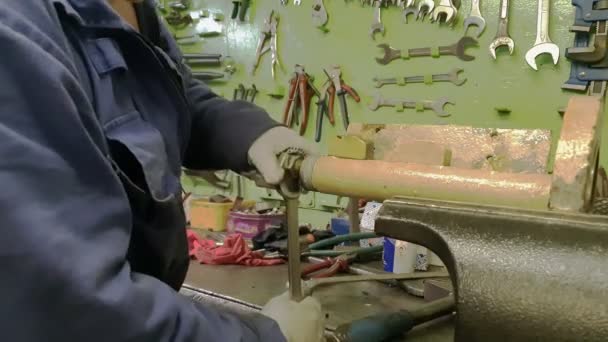 Mann schraubt weißes Detail mit Metallschlüssel ab — Stockvideo