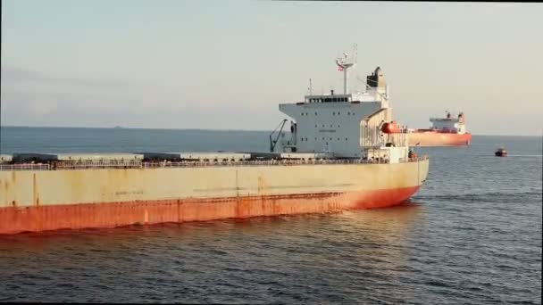 Огромные танкеры плывут по спокойной поверхности воды в солнечный день — стоковое видео