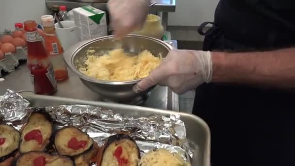 Koch von Tankschiff-Onyx rührt geriebenen Käse in Metallschüssel — Stockvideo