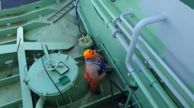 Turuncu başlıklı gemi işçisi, modern petrol tankeri boruları.
