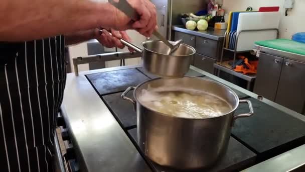 Cocinero experto reúne espuma blanca de plato hirviendo en olla — Vídeo de stock