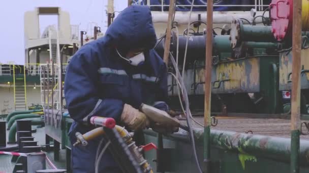 Natig Aliev tanker matroos reinigt vuile pijpleiding van roest — Stockvideo