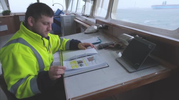 Cadete de cubierta se sienta y estudia la documentación de navegación — Vídeos de Stock