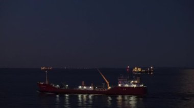 Işıklı tanker geceleri uçsuz bucaksız karanlık deniz boyunca yelken açar.
