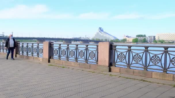 Pensionär i medicinsk mask promenader längs flodvallen — Stockvideo