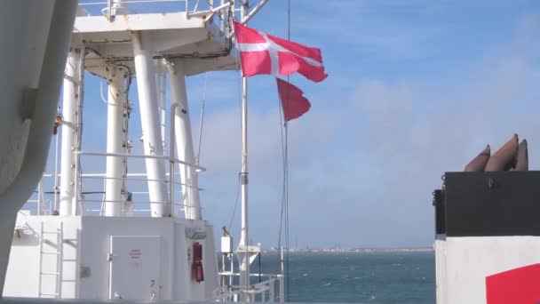 Bandeira dinamarquesa localizada em ondas de navios em forte vento no porto — Vídeo de Stock