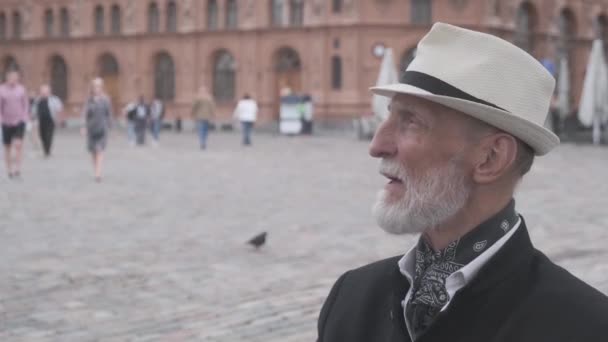 Plešatý důchodce sundává stylový klobouk na rozmazaném pozadí — Stock video