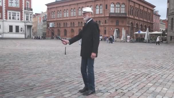 Homem sênior elegante faz selfie com telefone celular na praça — Vídeo de Stock
